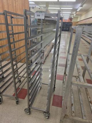 Mobile sheet pan rack with multiple shelves, metal construction, on wheels. Visible tag reads "358". Suitable for bakery or kitchen use.