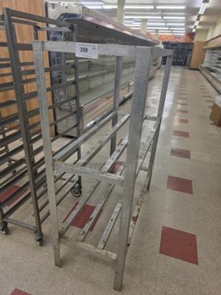 Industrial metal dunnage rack, two-tier, rectangular frame, numbered tag 359, used condition, for storage or display.