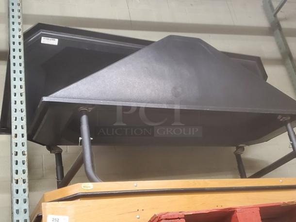 Black metal produce stand with slanted top, sturdy legs, and minimalist design. Good condition, ideal for retail display.