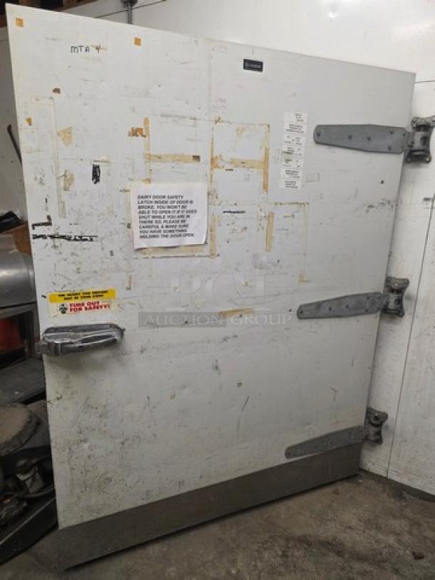 Walk-in door with hardware, shown with hinges and safety labels, in used condition. Suitable for commercial refrigerators.