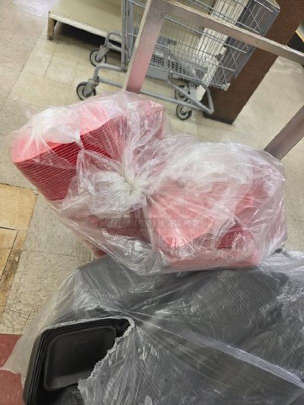 One lot of disposable food trays in pink and black, wrapped in clear plastic, unused and ready for catering use.