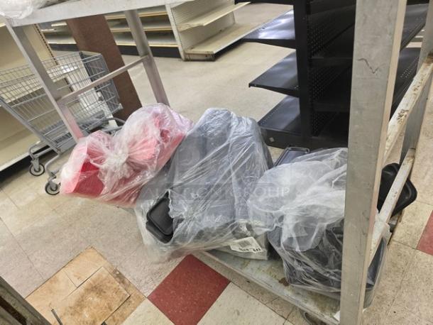 One lot of disposable food trays in plastic wrap on a cart, featuring various sizes and colors. Condition: new.