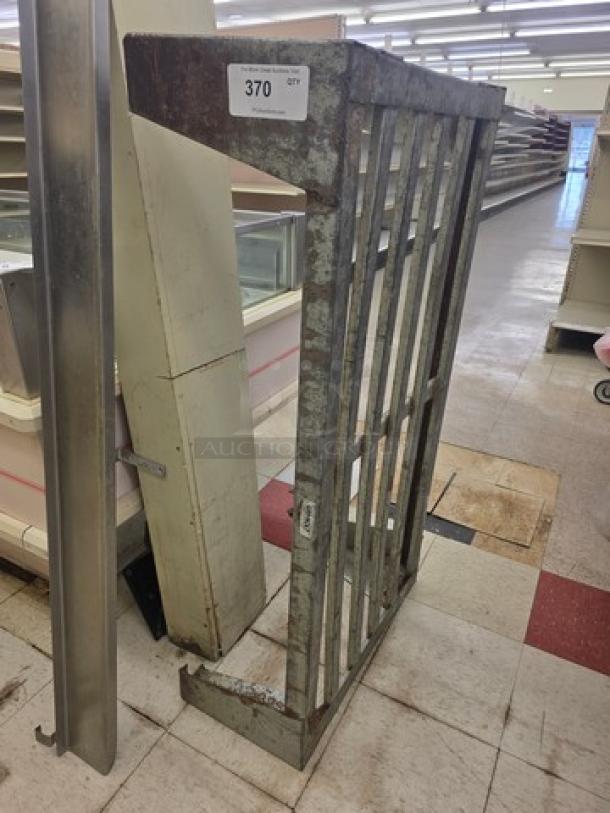 Metal dunnage rack, aged condition, vertical slats, label with "370 qty." Ideal for storage, durable industrial design.