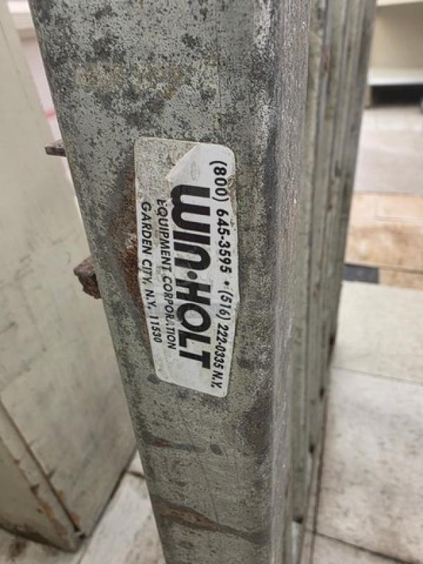 Win-Holt dunnage rack, metal construction, visible wear, label with contact info and location in Garden City, NY.