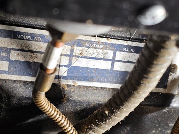 Commercial refrigeration compressor rack with visible model and voltage label, 40 HP, medium temp, 134A refrigerant.