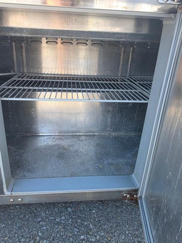 Continental SW72-30M 72″ Commercial Sandwich Prep Unit, stainless steel interior, moderate wear, visible shelving, door slightly ajar.
