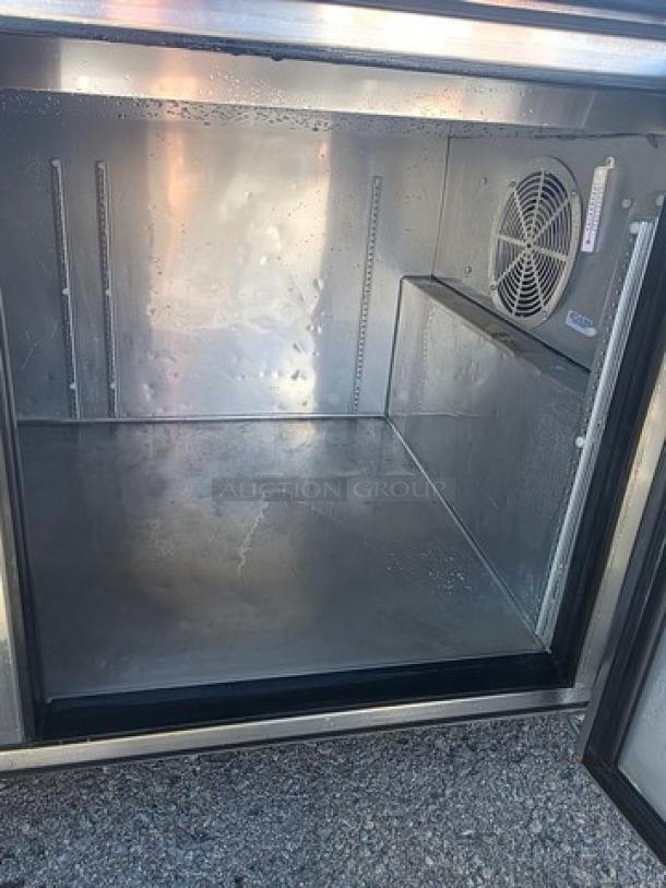 True 2 Door Pizza Prep Table TPP-67 interior, showing stainless steel shelving, fan, and temperature gauge. Clean condition.