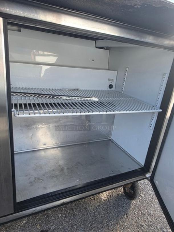 True QA-60-24M-B 60" Refrigerated Prep Table, open door view showing interior shelves, stainless steel, gently used condition.