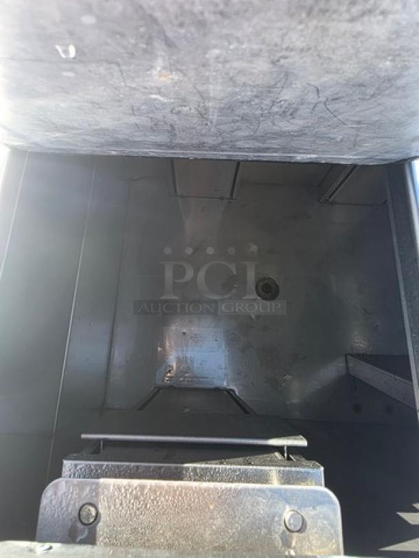 Delfield KCF-50 ice cream counter interior view, showing metal compartment, wear, and drainage hole.