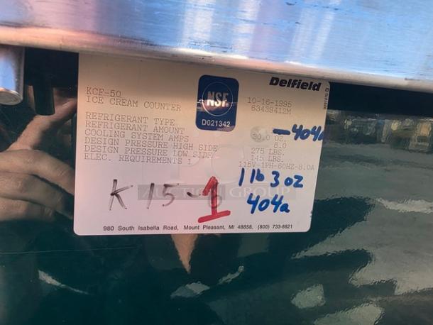Delfield KCF-50 Ice Cream Counter label showing model details, refrigerant type 404, electrical specs, and manufacturing info.