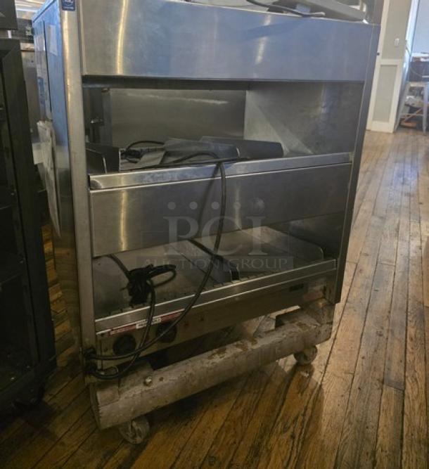 International Dairy Queen DD29 Double Level Food Warmer, stainless steel, used condition, visible cords, on wheels.