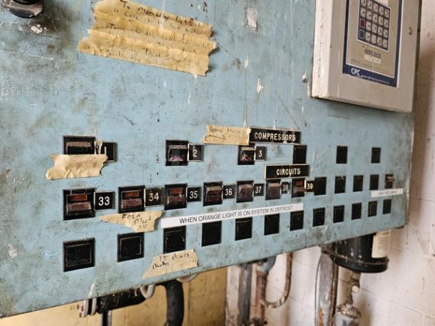 Commercial refrigeration compressor rack panel with circuit switches and labels. Medium Temp. 404A, 40 HP. Worn condition.