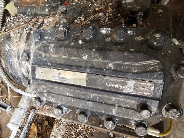 Commercial refrigeration compressor rack, medium temp, 40 HP, Copeland brand, Emerson logo, shows signs of use.