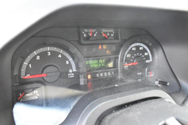 Dashboard view of a 2012 Ford E-350 Van showing odometer reading 96,764 miles and fuel gauge.