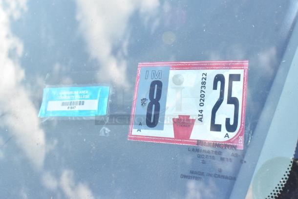 2012 Ford E-350 Van with 96,764 miles; visible PA inspection sticker for 8/25 and Harrisburg Area Community College parking permit.