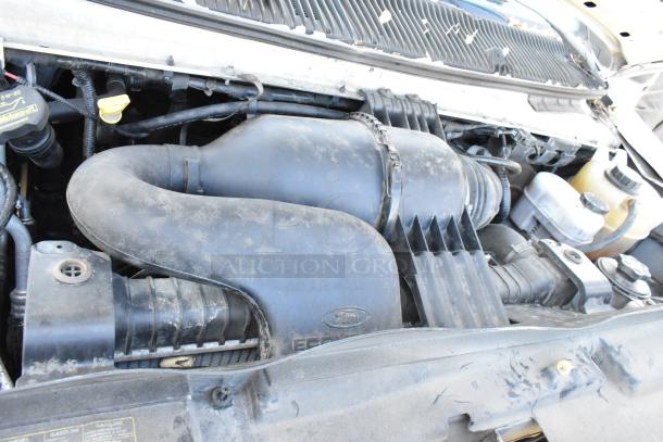 Engine compartment of a 2012 Ford E-350 Van, showing engine parts with Ford logo. Odometer: 96,764. VIN: 1FBSS3BL3CDA01043.
