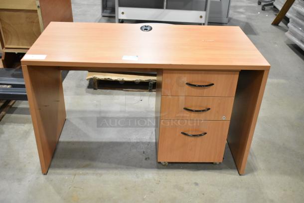 Wood pattern desk with 3-drawer filing cabinet, black handles, and smooth finish. Minor wear visible.