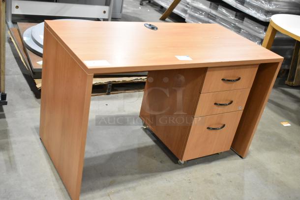Wood pattern desk with three-drawer filing cabinet, metal handles, in good condition. Features cable management grommet.