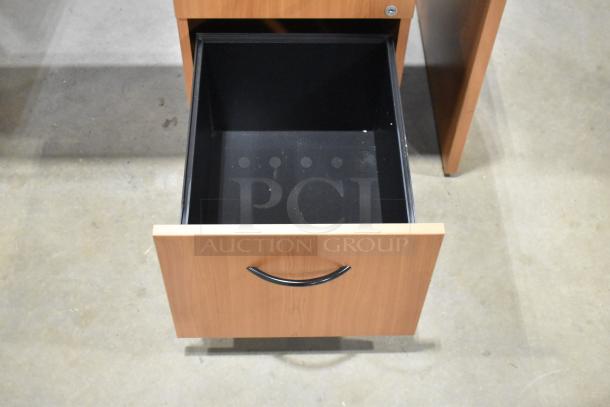 Wood pattern desk with open filing cabinet drawer, showing spacious interior. Features three drawers, sturdy design, good condition.