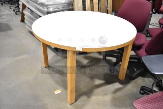 Round white table with wood pattern rim and legs, in good condition. Ideal for dining or conference use.