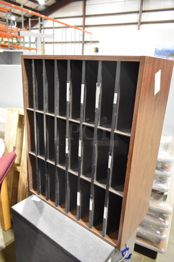 Wooden 24 cubby mailer with labeled slots, in used condition. Part of a lot with a gray 2-drawer filing cabinet.