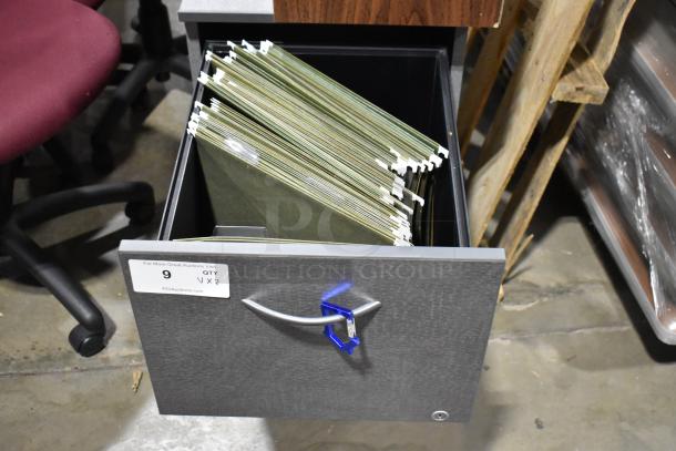 Gray 2-drawer filing cabinet with open drawer showing green hanging folders. Label indicates quantity of 2 items.