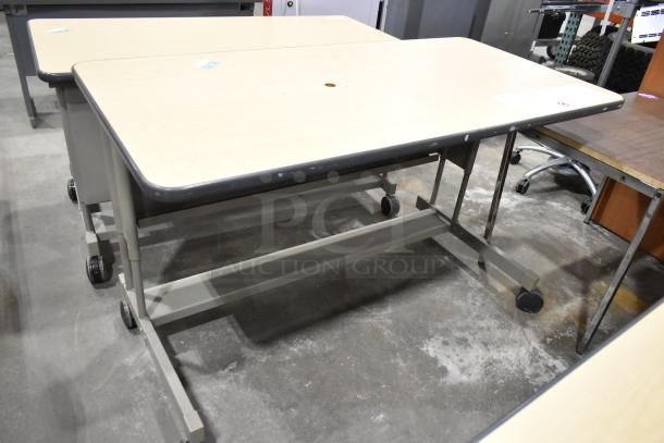 Three versatile desks on casters; light wood top, metal frame, and mobile design enhance workspace flexibility.