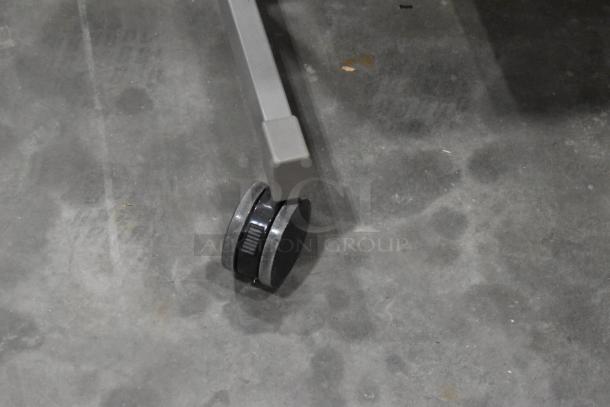 Three desks with metal legs on black casters for easy mobility, in used condition.