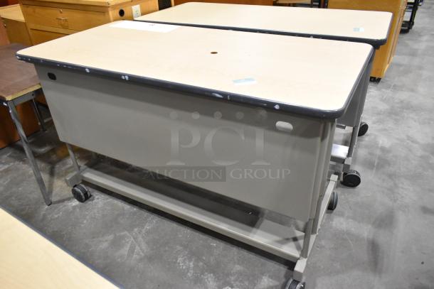 Three desks on casters with light wood tops and gray metal frames, showing minor wear. Auction lot with multiple units.