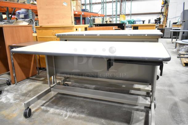 Three desks on casters, featuring metal frames and light tabletops. Used condition, perfect for office or home workspace.