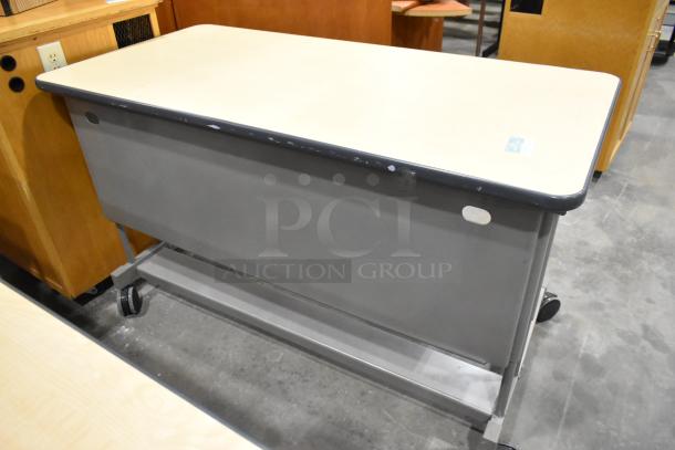 Three office desks on casters, light wood top, metal base, minor wear visible, mobile and versatile.