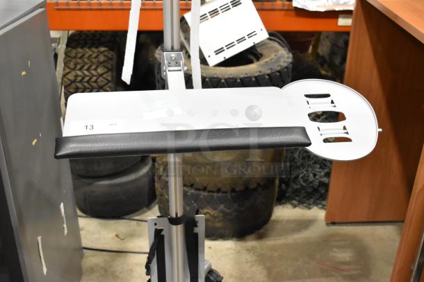 Portable stand on casters with adjustable height, black padded shelf, and white plate holder. Slightly used condition.