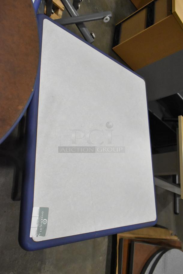 Four tables, including round and rectangular shapes, in various conditions. One with an "Overnight Delivery" label.