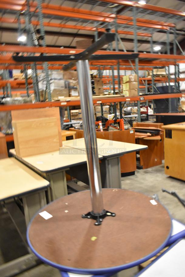 Four varied tables including round and rectangular models. Mixed wood and metal designs, used condition. Warehouse setting.