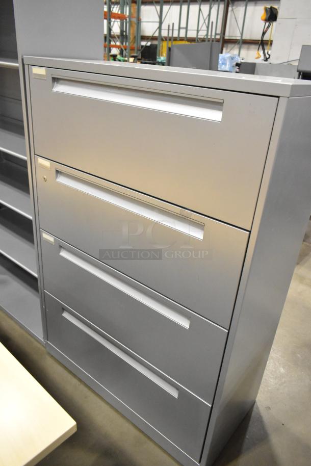 Gray metal 4-drawer filing cabinet, excellent condition, with a visible bookshelf in the background, ideal for office use.