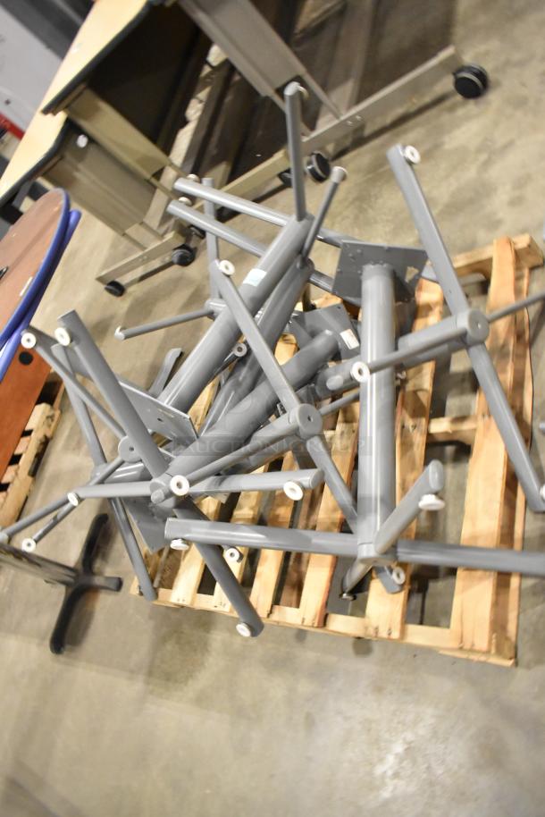 3 pallets of round gray tabletops and gray metal table legs, stacked together. Mixed condition.