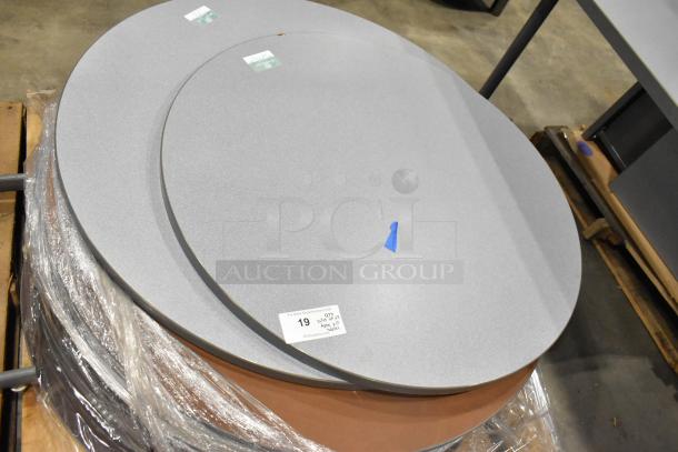 Three pallets with various items, including round gray tabletops and gray metal table legs, labeled for auction sale.