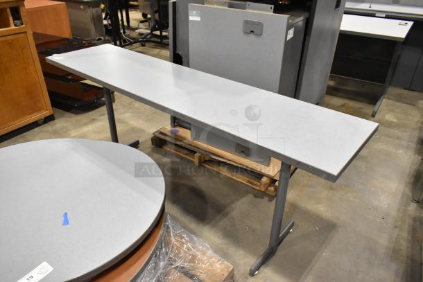 Set of three gray desks, each with a smooth surface and metal legs. In good condition, ideal for office use.