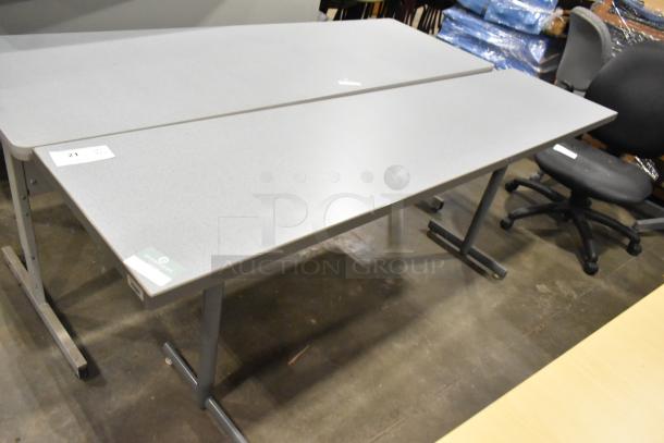 Three gray desks in good condition, with metal legs. Includes bid tag number 21 and a green Overstock label.