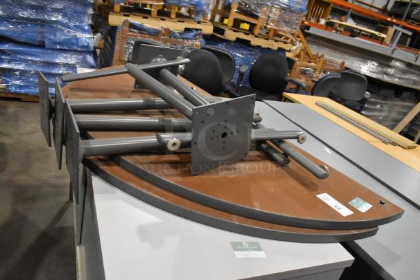 Metal 2-door cabinet and disassembled tabletop with legs; bid includes two of each item. Cabinet in background, tabletop metal base visible.