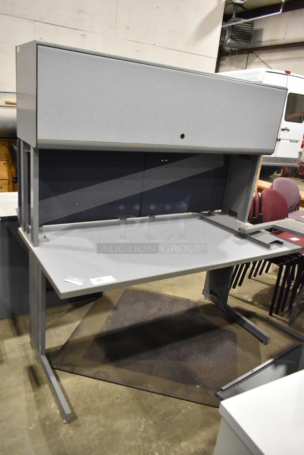Gray desk with overhead cabinet, sleek design, durable condition, number 24 tag on surface, ideal for office use.