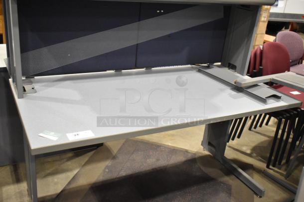 Gray desk with overhead cabinet, features smooth surface, sturdy legs, and integrated cable management. Excellent condition.