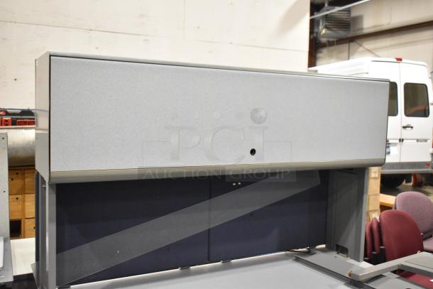 Gray desk with overhead cabinet, modern design, good condition, ideal for office use.