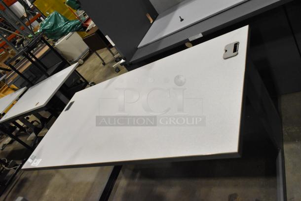 Gray desk with metal legs, cable management cutouts, and minor wear. Suitable for office or home use.