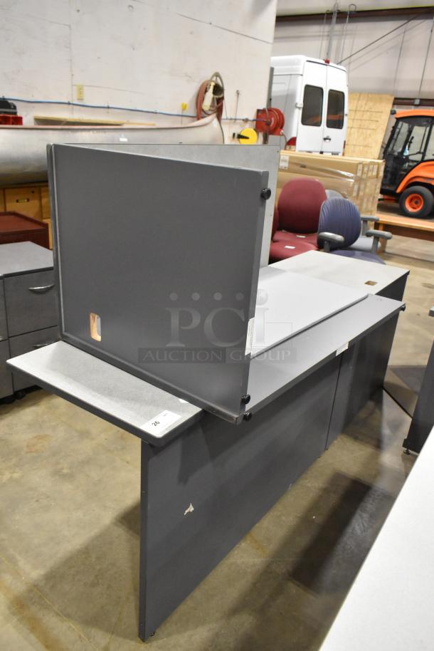 Gray desk in two pieces in fair condition, featuring a side panel and modesty panel. Some surface marks visible.