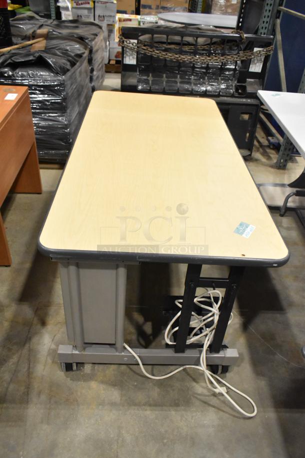Four varied desk/table set, beige tops, metal legs, visible cables. Good condition, auction label attached. Ideal for office use.