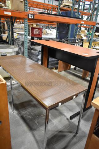 Two wood-patterned items: a rectangular table with chrome legs and a desk with a black frame. Mild wear visible.