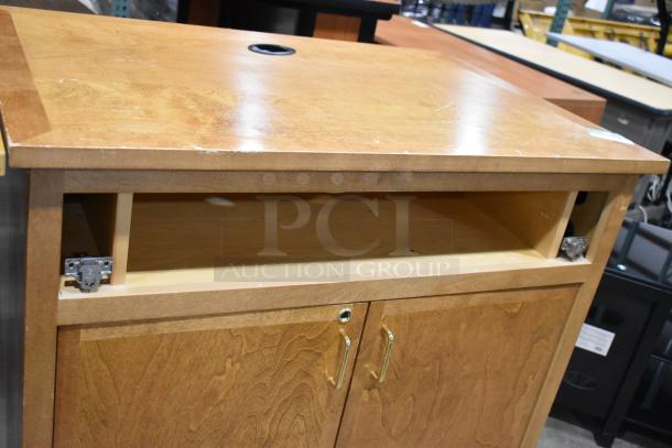 Wood pattern counter with two doors and a missing drawer. Features brass handles and scratch marks on top surface.