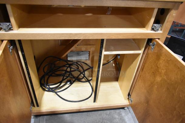 Wood pattern counter with one drawer and two doors. Missing second drawer. Contains visible cords inside.