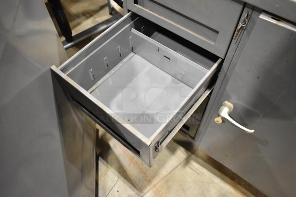 Gray metal cart with four drawers and door, featuring sturdy construction and commercial casters for mobility. Key lock shown.